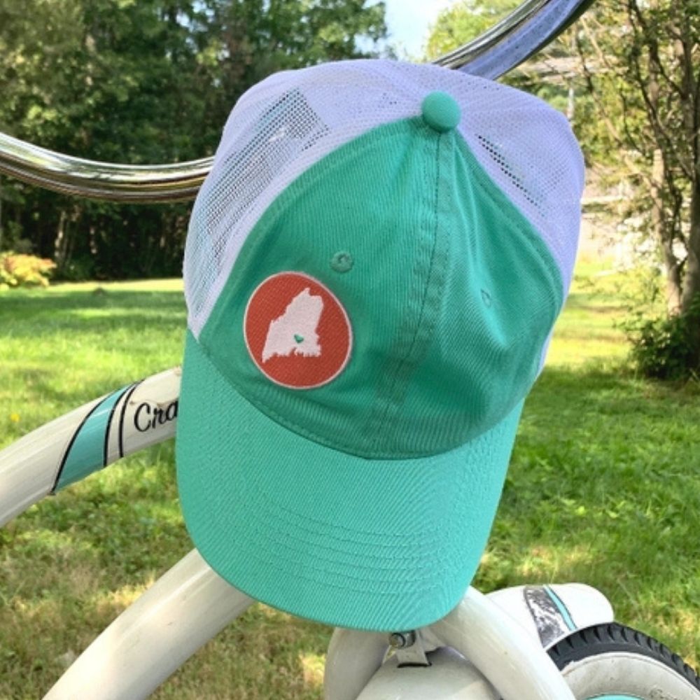 Mint green and white cap with a red circle featuring a map of Maine on a white background