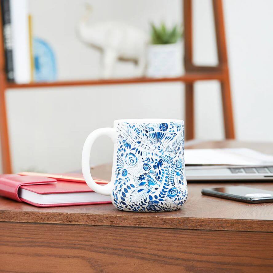 White coastal coffee mug with blue floral pattern on a white background