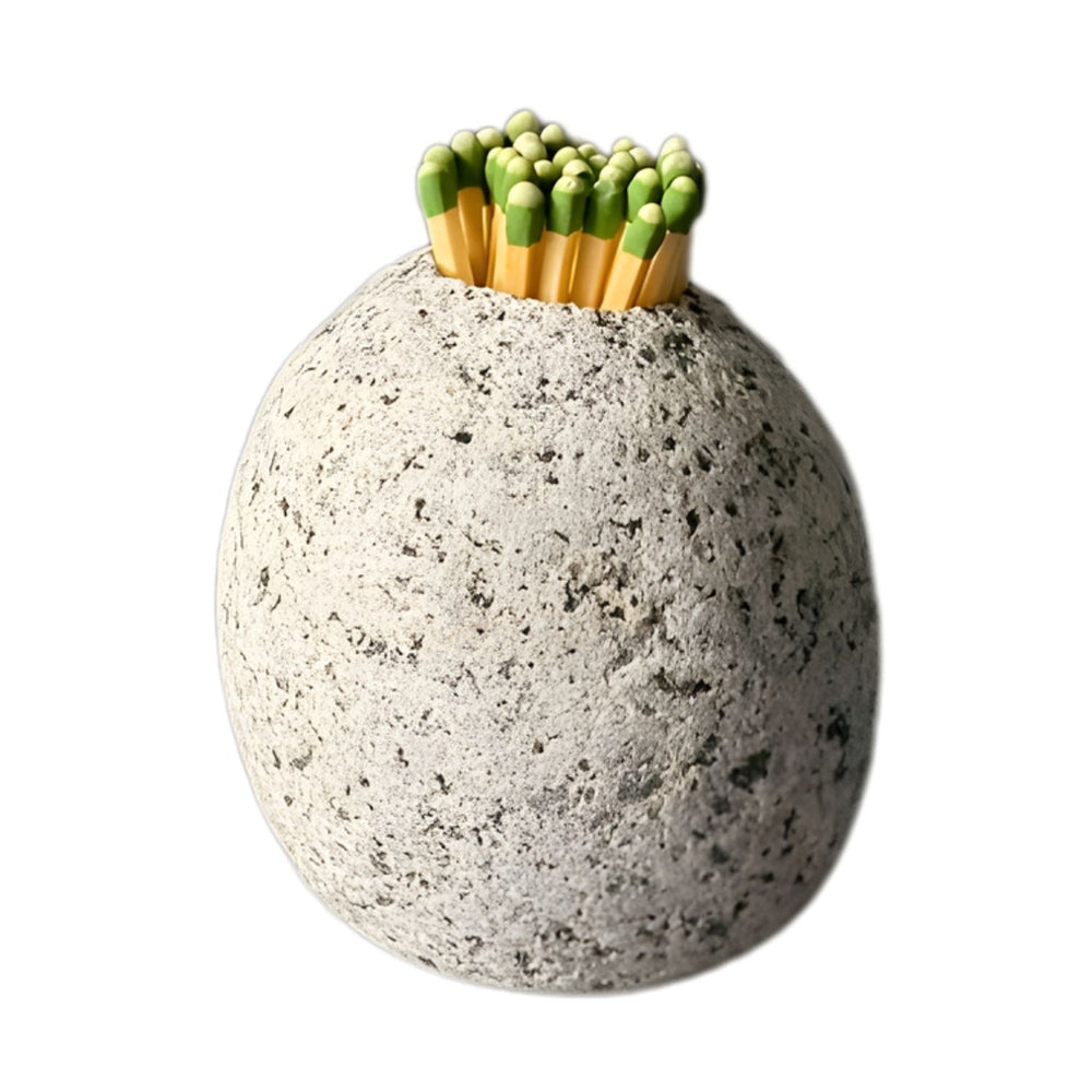 A single, round, gray speckled stone holder standing on a white surface, filled with a bundle of strike anywhere matchsticks.