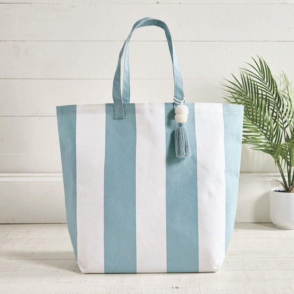 Blue cabana stripe beach tote styled in coastal setting