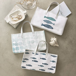 Large canvas tote with blue coastal fish pattern styled with coastal décor and books