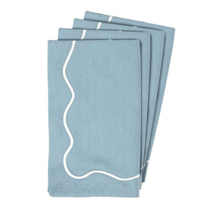 Set of four blue embroidered scalloped cotton napkins folded.