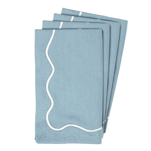 Set of four blue embroidered scalloped cotton napkins folded.