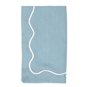 Blue cotton napkin with white embroidered scalloped border, folded.