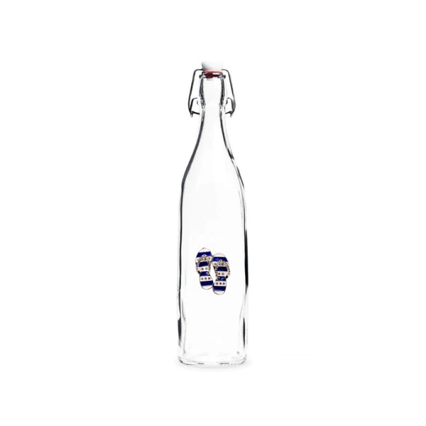 Clear glass bottle with blue and white jeweled embellishment evoking seaside charm.