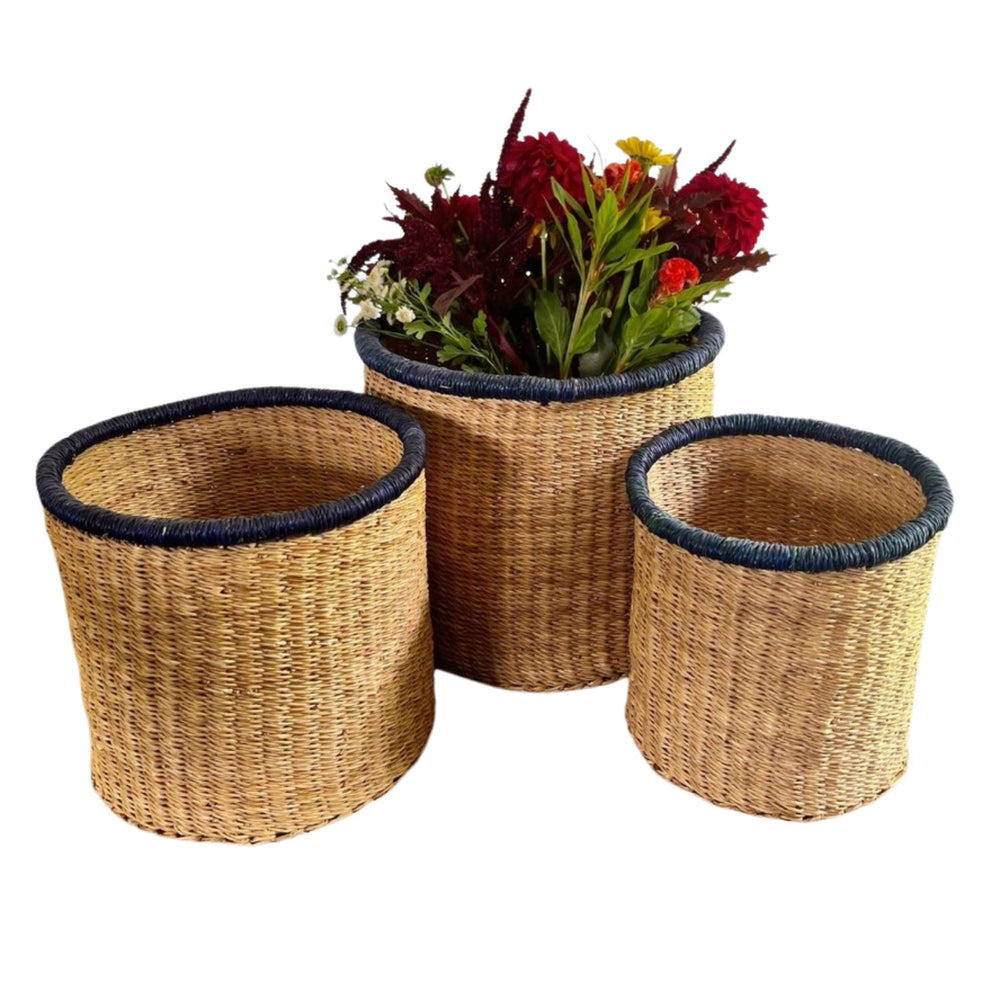 Full set of three Indigo Rim Artisan Baskets in small, medium, and large sizes, handwoven in Ghana with natural grasses and a bold indigo rim accent.