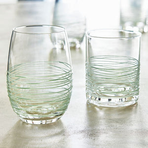 Coastal blue textured spun stemless wine glasses with raised swirl detail on table.