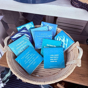 Blue and teal cocktail napkins with funny sayings on display 