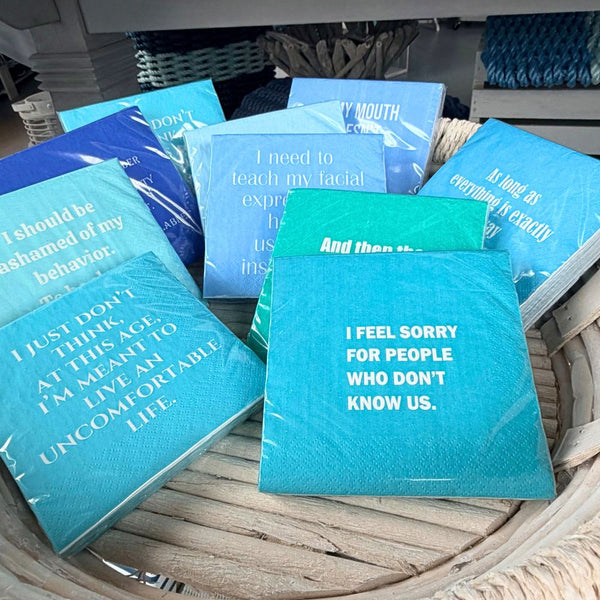 Blue and teal cocktail napkins with funny sayings on display 