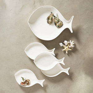 Set of white ceramic fish appetizer plates styled with oysters and coastal décor