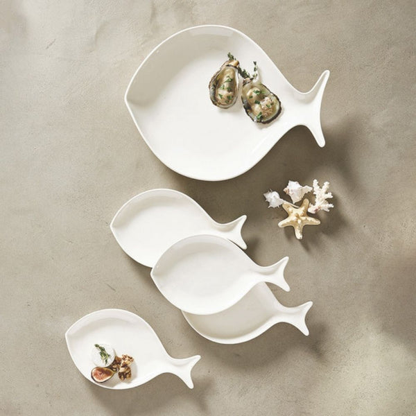 Set of white ceramic fish appetizer plates styled with oysters and coastal décor