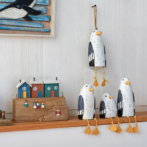 Three hand-carved wooden seagulls in small, medium, and large, featuring a distressed white finish and yellow rope legs.