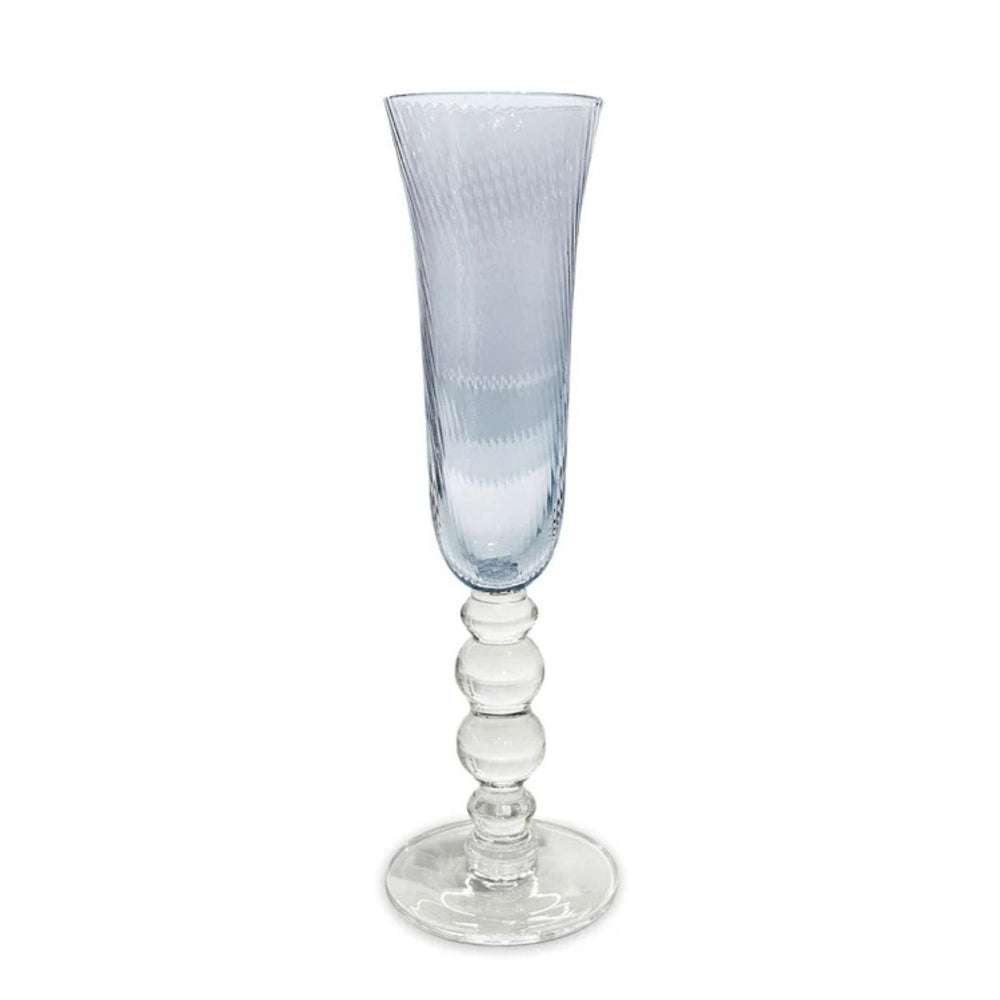 Set of four blue champagne flutes with swirl optic bowls, reflecting light like ocean waves for a coastal-inspired table.