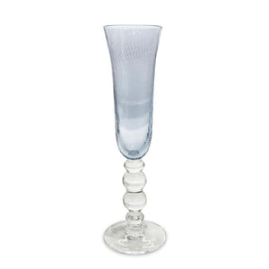 Set of four blue champagne flutes with swirl optic bowls, reflecting light like ocean waves for a coastal-inspired table.