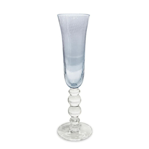 Set of four blue champagne flutes with swirl optic bowls, reflecting light like ocean waves for a coastal-inspired table.