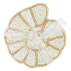 Stack of shell-shaped glass bead coasters in neutral coastal tones