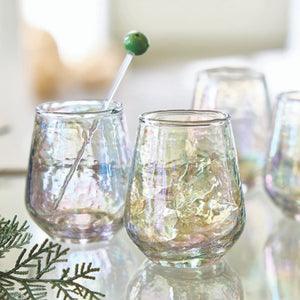 Set of grey iridescent luster stemless wine glasses reflecting light on mirrored surface