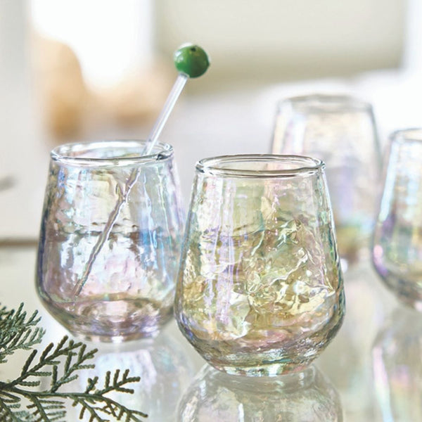 Set of grey iridescent luster stemless wine glasses reflecting light on mirrored surface