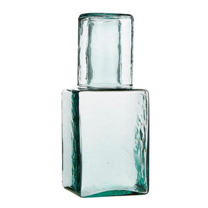 Angled view of hammered recycled glass carafe with matching tumbler lid on top