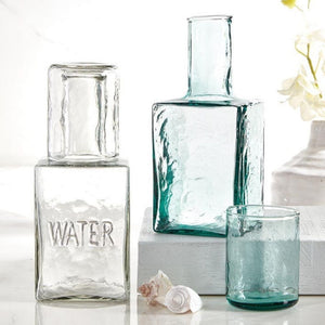 Angled view of hammered recycled glass carafe with matching tumbler lid on display