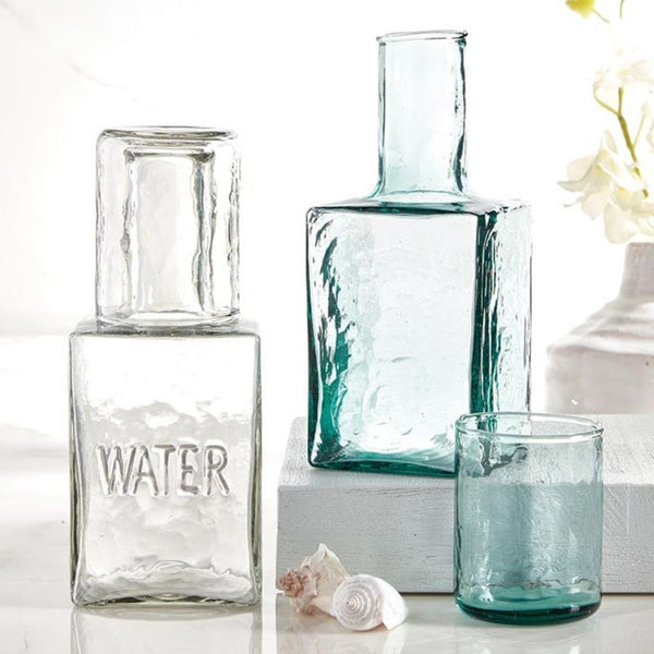 Angled view of hammered recycled glass carafe with matching tumbler lid on display