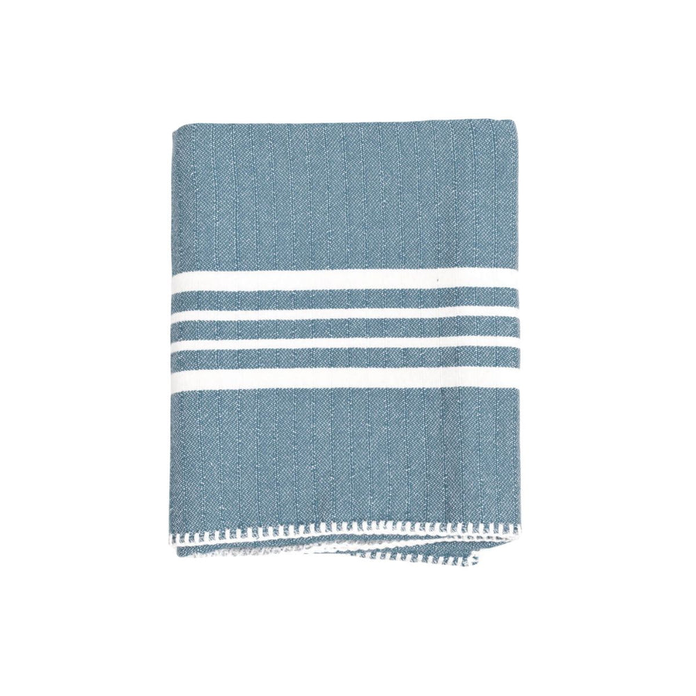 Soft sun-kissed Turkish towel neatly folded, highlighting premium hand-stitched edge