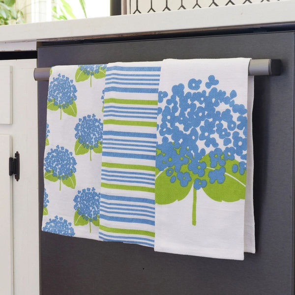 Set of 3 coastal sustainable microfiber tea towel with blue hydrangea print, hanging on oven handle