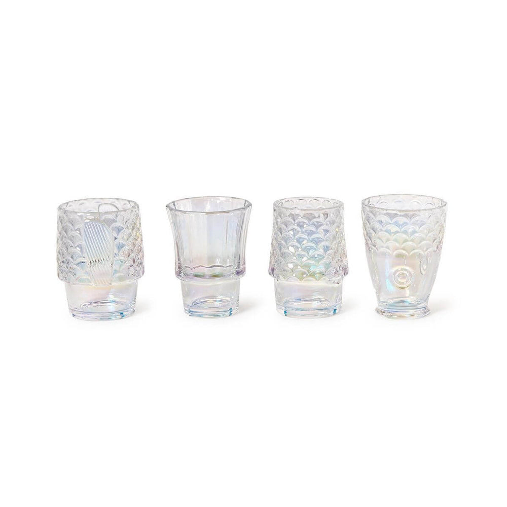 Set of four iridescent fish glasses with embossed design stacked together on a coastal-style table