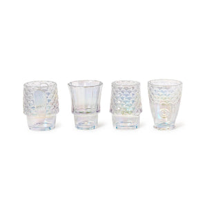Set of four iridescent fish glasses with embossed design stacked together on a coastal-style table