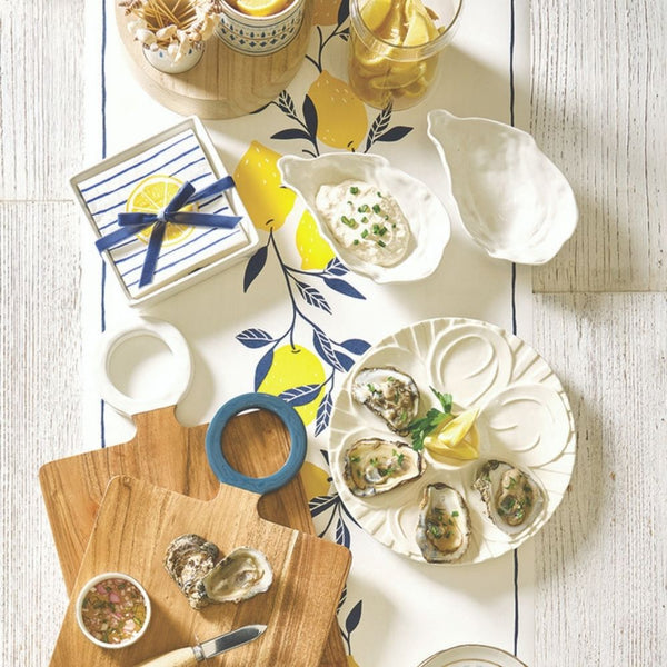 Lemon print paper table runner styled on a table with coastal dishes and serving boards