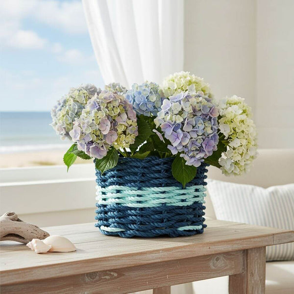 Colorful rope basket with a sturdy base, perfect for use as a planter, organizer, or decorative accent at home or outdoors