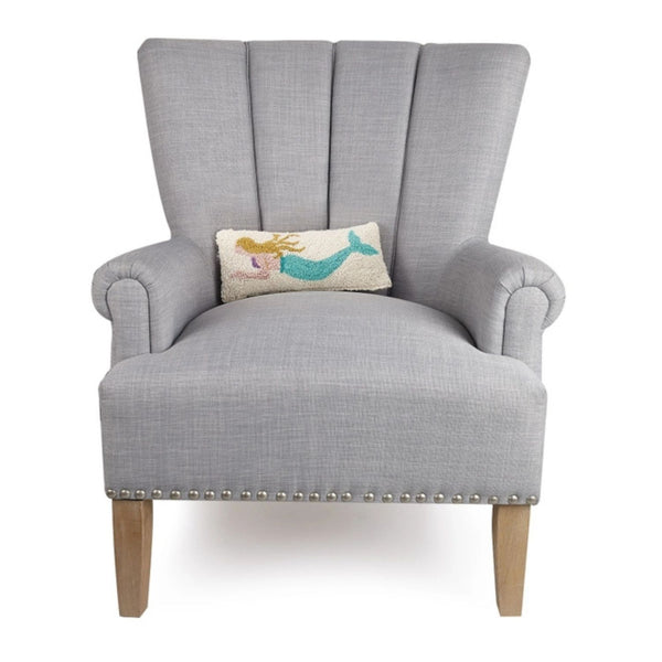 Decorative coastal lumbar pillow with mermaid motif set on chair