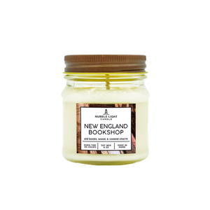 Scented soy candle in a clear glass mason jar, inspired by a cozy New England bookshop with a subtle coastal warmth.