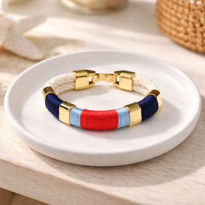 Coastal-inspired hand-dyed cotton rope bracelet with gold-plated details, perfect for layering.