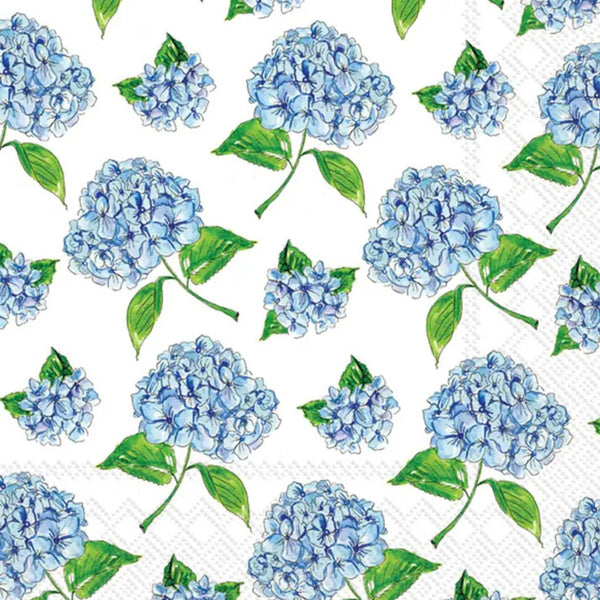 Elegant paper cocktail napkins featuring blue hydrangea florals and lush green leaves on a crisp white background, perfect for a coastal spring table.