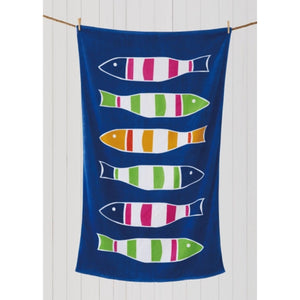 Blue beach towel with fish design hanging on rope against white wall