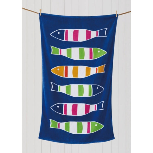 Blue beach towel with fish design hanging on rope against white wall