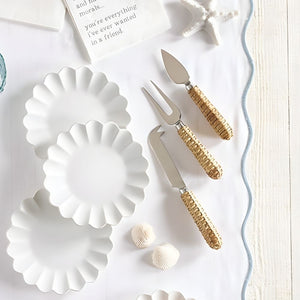 Rattan handle cheese knives set of 3 on  a white wood table