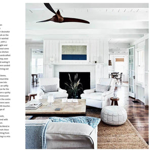 Modern living room with white furniture, wooden coffee table, and decorative elements.