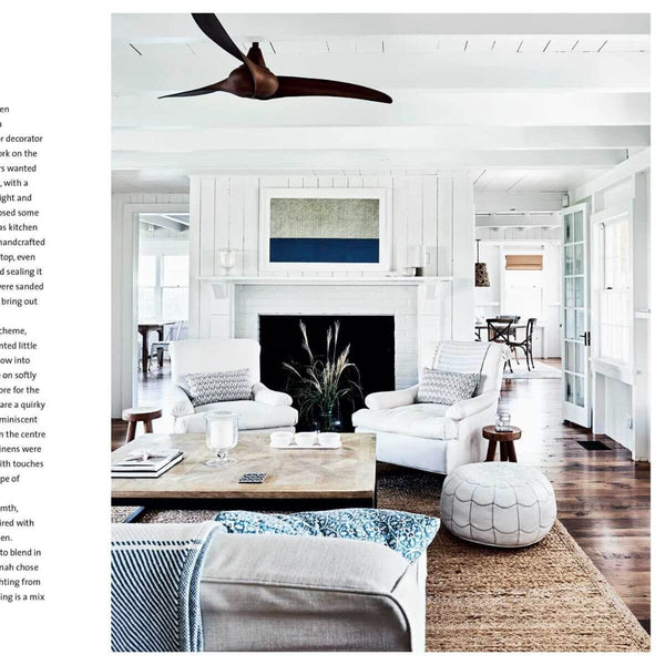 Modern living room with white furniture, wooden coffee table, and decorative elements.