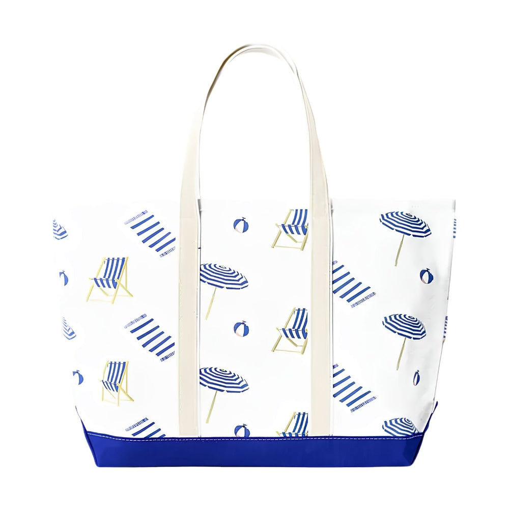 Front view of a white canvas tote bag with a royal blue base, featuring a repeating pattern of blue-striped beach umbrellas, chairs, and towels.
