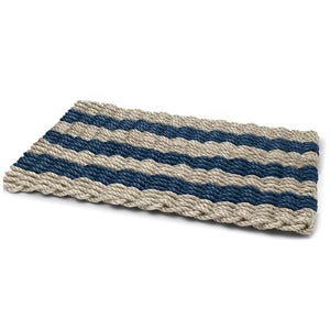 Angled view of a sand and navy cabana stripe doormat, bringing coastal style to entryways.