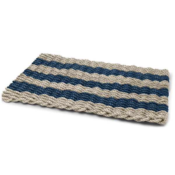 Angled view of a sand and navy cabana stripe doormat, bringing coastal style to entryways.
