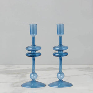Two small sapphire blue glass candlesticks, adding a pop of color and coastal charm to any table, coastal home decor