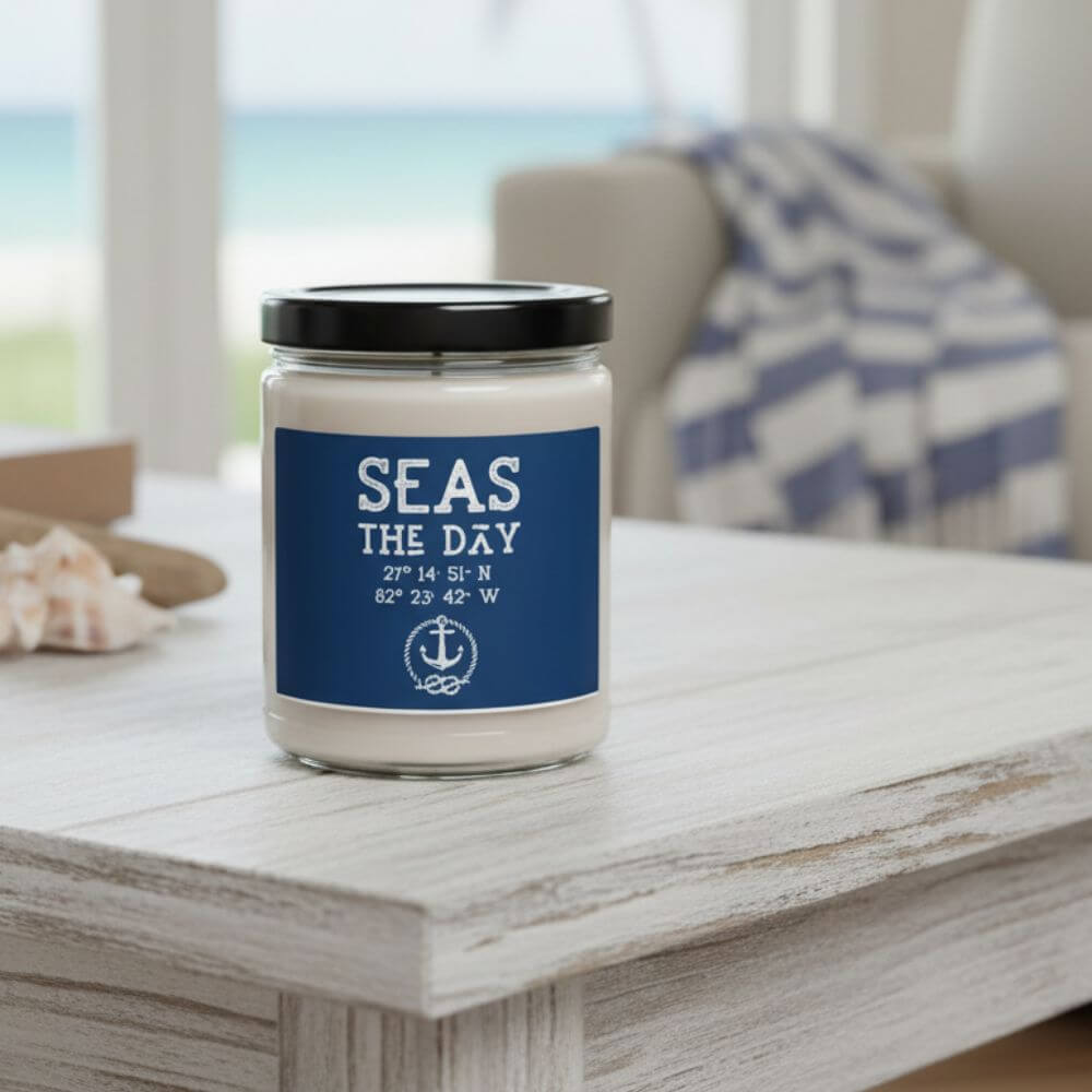 Coastal-themed candle jar with ‘SEAS THE DAY’ label placed on a wooden surface, featuring an ocean-inspired background, nautical home décor accent