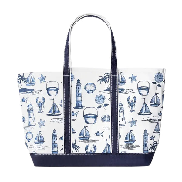 Front view of a white canvas tote bag with a dark navy blue base and handles, featuring a blue repeating pattern of coastal motifs like sailboats, lighthouses, and lobsters.