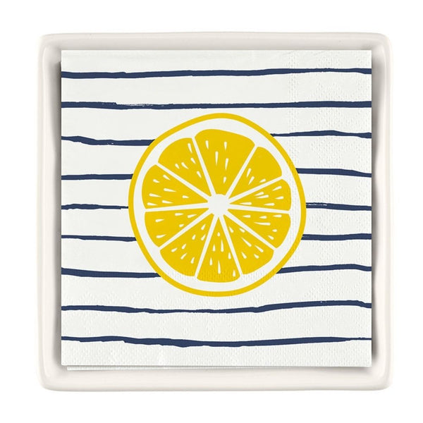 Striped lemon cocktail napkins displayed in a white ceramic napkin tray