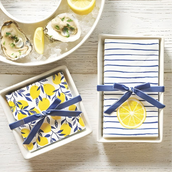 Ceramic napkin tray with lemon napkins tied with navy ribbon displayed on table 