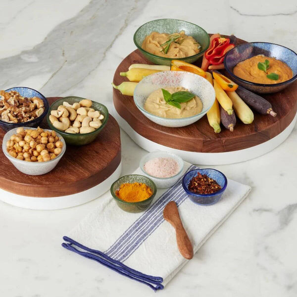 Assorted nuts, seeds, and dips on a marble surface with a wooden board and Vintage Navy Blue Stripe Dinner Napkins, Set of 4