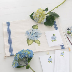 Watercolor hydrangea tea towel with blue floral design and vintage stripe, offering a timeless New England coastal style for the kitchen.